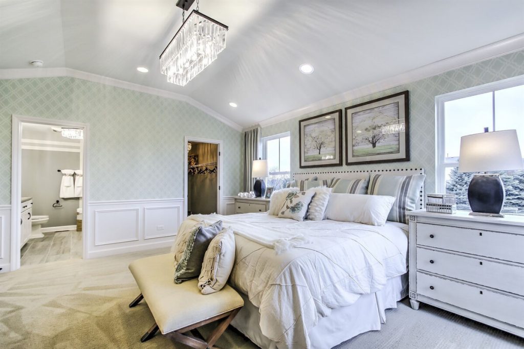 Wallpapered bedroom with vaulted ceiling.